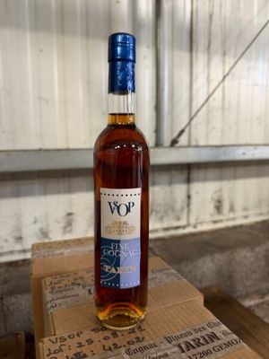 the bottle of wine is sitting on top of a cardboard box
