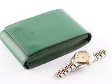 a watch sitting next to a wallet on a white surface