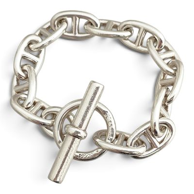 bracelet à chaîne en argent orné d'une croix, sur fond blanc