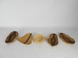 four wooden spoons and a wooden spoon rest on a white surface