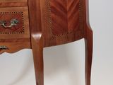a small wooden cabinet with a marble top on it