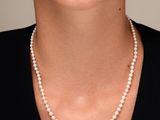 un gros plan d'une femme portant un collier de perles