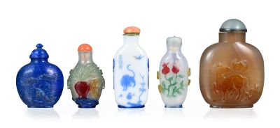 plusieurs vases en verre de différentes couleurs sont alignés sur une surface blanche