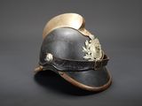 an old helmet with a leaf on the side of it on a black background