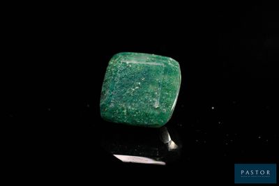 gros plan d'une pierre verte sur une surface noire