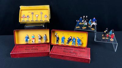 de nombreuses figurines représentant des personnes, rangées dans une boîte posée sur une table