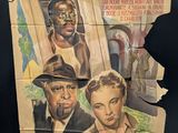 a very old movie poster on the wall of a building