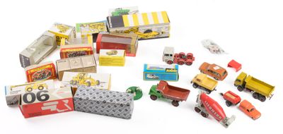 un tas de petites voitures et de camions miniatures posés sur une surface blanche