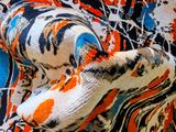 a close up picture of a stuffed animal on a colorful blanket
