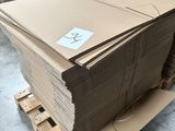 Plusieurs piles de cartons sont empilées sur une palette dans un entrepôt