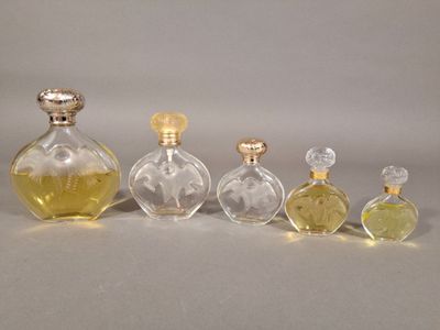 trois flacons de parfum posés l'un à côté de l'autre sur une table