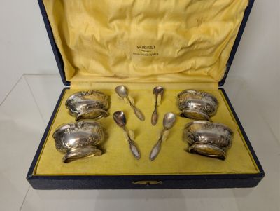 six silver spoons in a case on a table