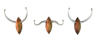 trois crochets métalliques auxquels sont suspendues de longues cornes, fixés au mur