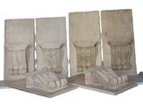 quatre pièces de pierre sculptée reposent sur une surface blanche
