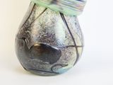 a glass vase with a bird on top of it