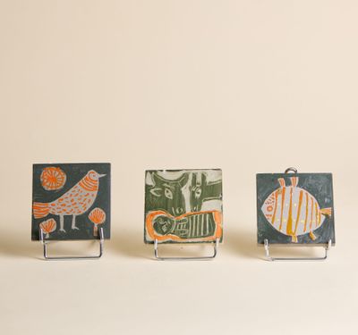 trois petites pièces en céramique, de formes et de tailles différentes, reposent sur une surface blanche