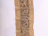 un vieux morceau de tissu sur lequel sont inscrits des mots, posé sur une table