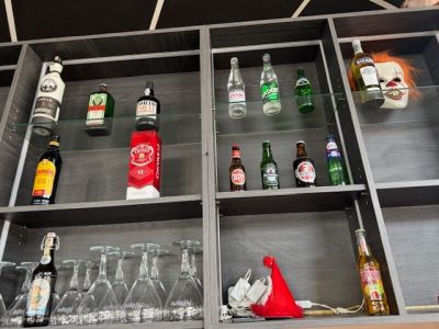 de nombreuses bouteilles et verres sur les étagères d'un bar