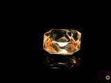 a close up of a yellow diamond on a black surface