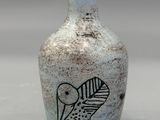 un petit vase orné d'un oiseau, posé sur une table