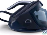 a black and blue steam iron sitting on a white surface
