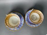 two cups and saucers are sitting on a table