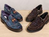 two pairs of shoes sitting on top of a wooden table