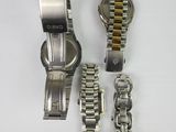 two watches and a bracelet are sitting on a white surface