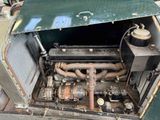 an old green car with a large engine inside of it