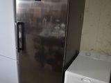 un réfrigérateur argenté et une machine à laver blanche dans une pièce