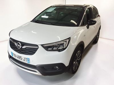La voiture blanche est garée dans une pièce blanche au sol blanc.