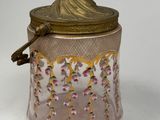 an image of a pink glass jar with a gold lid