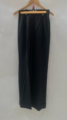 a black pants hanging on a hanger against a white wall