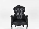 a black leather chair sitting on top of a white floor