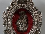 an ornate silver and red broochle with a crown on top of it