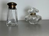 two bottles of perfume sitting on a table next to each other