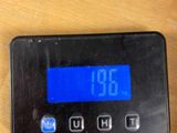 a digital clock that is on the table next to a cell phone