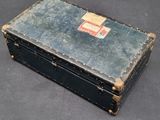 an old suitcase with a tag on it sitting on a table