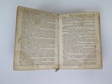 an old open book with writing on it sitting on a table