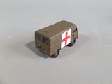 a toy truck with a red cross on the side of it