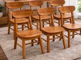 des chaises en bois et une table dans une pièce recouverte d'un tapis blanc