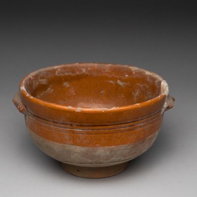 un bol marron et blanc posé sur une surface grise