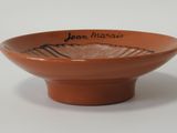 a brown bowl with writing on it sitting on a table