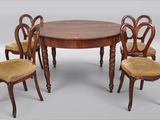 quatre chaises disposées autour d'une table au plateau en bois