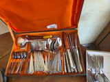 une valise remplie d'argenterie posée sur une table en bois