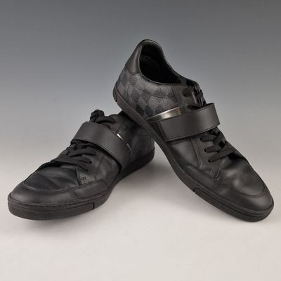 une paire de chaussures en cuir noir avec un motif à carreaux sur le côté