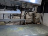 a picture of a dirty bathroom with pipes and a sink