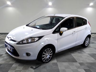 la ford fiesta blanche est garée dans une pièce au sol à carreaux