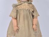 an antique doll with blonde hair wearing a dress and boots