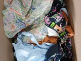 a cardboard box filled with clothes and a blanket